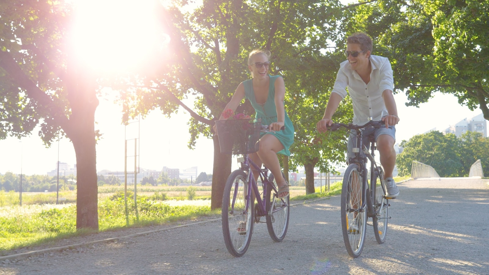 Cheerful blonde woman and her boyfriend enjoy a sunny summer day by riding bikes on the Madison bike trails in Wisconsin